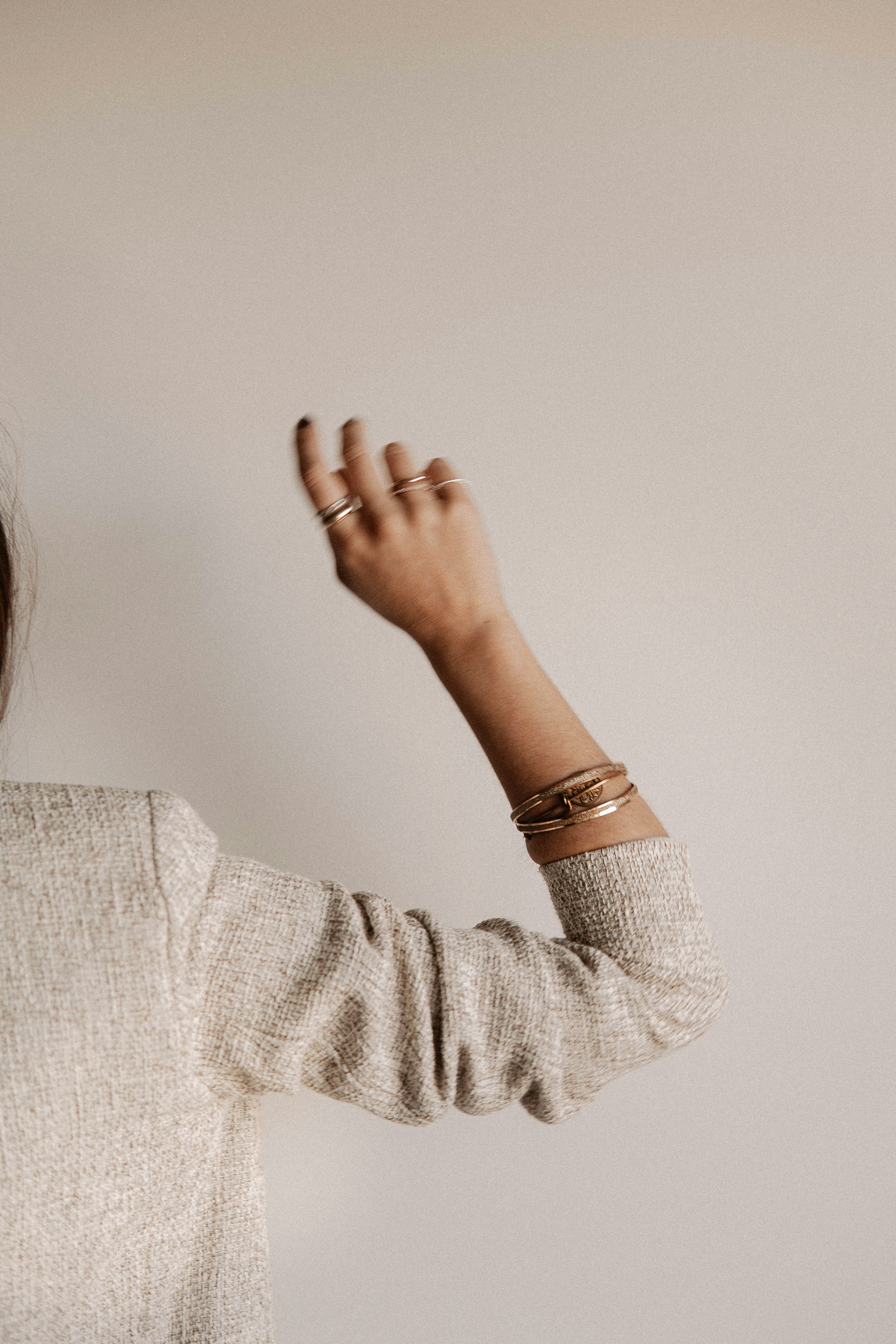 woman in gray sweater covering her face with her hand